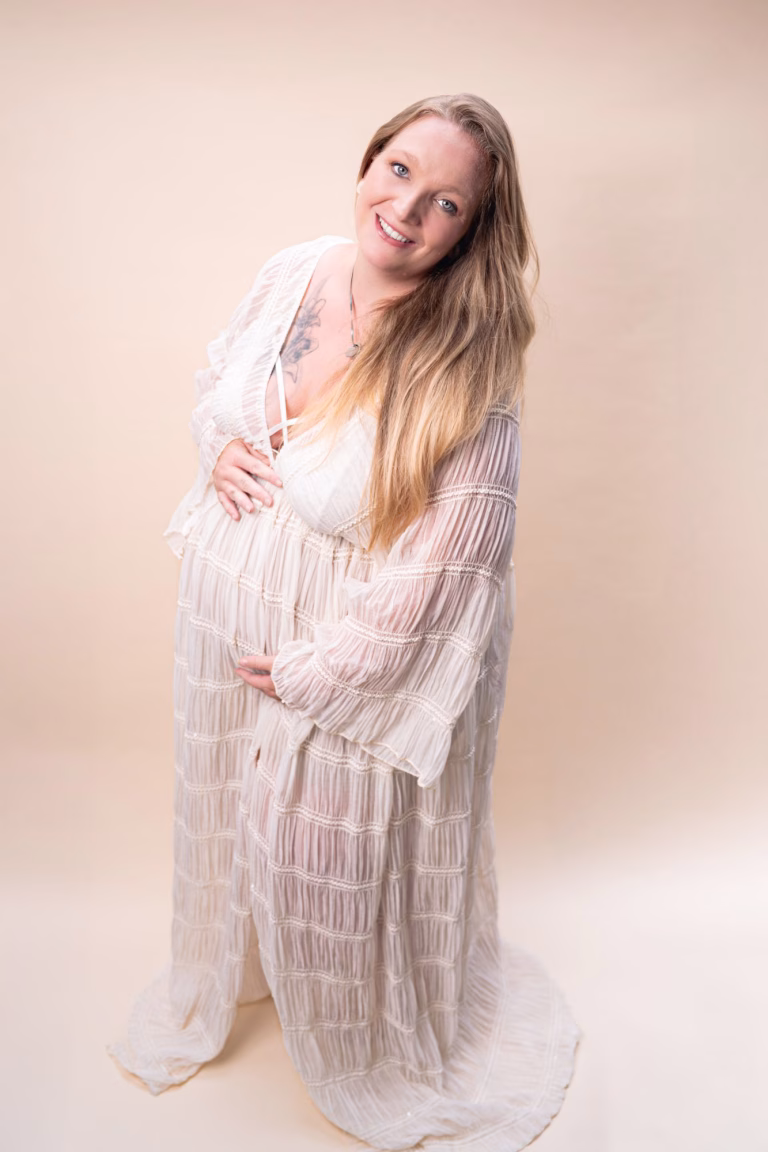 Zwangere vrouw in studio tijdens fotoshoot in Zuid-Limburg Pure zwangerschapsfoto met zachte lichtinval Fotograaf legt liefdevolle zwangerschap vast Zelfgemaakte zwangerschapsfoto bij 24 weken zwangerschap Emotionele zwangerschapsfoto met warme sfeer